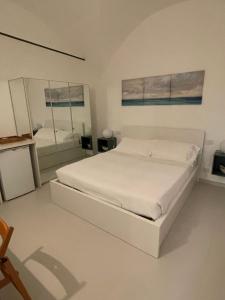 卡莫利La Casa di Alessia的白色卧室配有床和镜子