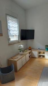 伊尔梅瑙Himmelblau的客厅配有电视、桌子和窗户。