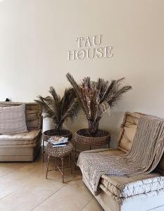 瓜塔佩Tau House的客厅设有两张沙发和一个标有税务所的标志