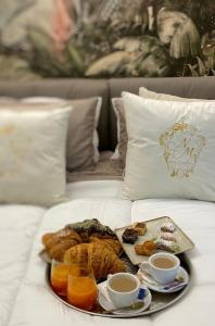 庞贝NM Luxury Suites的床上的早餐盘