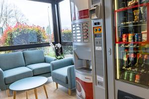博讷Vini Hotel的客厅配有冰箱和沙发。