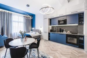 托伦Apartament 21A- Hvile Stay的厨房以及带蓝色橱柜和桌子的客厅。