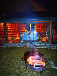 RybakiWilla Siemianówka - Sauna, Jacuzzi的夜间在房子前烧烤