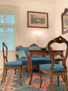 鲍洛通塞迈什Villa Bagolyvár的一间带桌子和两把椅子的用餐室