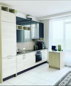 里加Jaunā Teika Penthouse的厨房配有白色橱柜和水槽