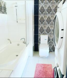 里加Jaunā Teika Penthouse的浴室配有白色浴缸和卫生间。