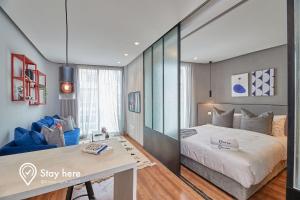 卡萨布兰卡Stayhere Casablanca - Palmier - Executive Residence的一间卧室配有一张大床和一张蓝色的沙发