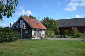 赫加奈斯Hönshuset Kullabygden的一座红色屋顶的房子和一个院子