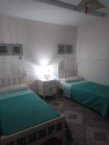特尔马斯德里奥翁多Casa Termas的一间卧室配有两张床和一张带台灯的桌子