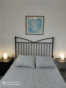巴尔韦尔德Apartamento Puerto de la Estaca 1的一间卧室配有一张带两盏灯的床,墙上挂着一张照片