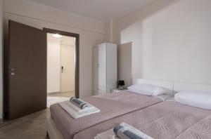 普萨克迪亚mansion luxury apartment的一间白色卧室,配有两张床和镜子