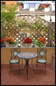 罗马Lilium Boutique Hotel的天井桌子和两把椅子,配有桌子和鲜花