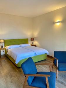 利莫内-苏尔加达Residence Dalco Suites & Apartments的一间卧室配有一张大床和两张蓝色椅子