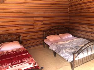 瓦迪拉姆萨勒姆营地酒店的木墙客房的两张床