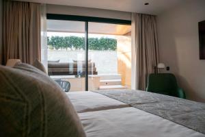 马斯帕洛马斯TenSuites - Adults Only的酒店客房设有一张床和一个大窗户
