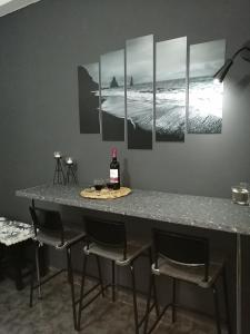 佩里萨Comfortbnb -Sabbia Calda 8的一张桌子、四把椅子和一瓶葡萄酒