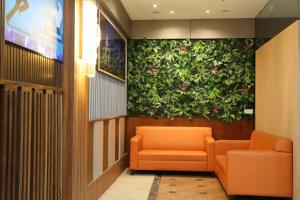 吉隆坡Orkid Hills Hotel的一间设有橙色椅子和绿色墙壁的等候室