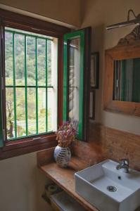 埃尔博斯克Casa Rural El Vihuelo的一间带水槽和镜子的浴室以及窗户。