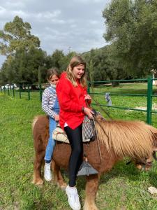 埃尔博斯克Casa Rural El Vihuelo的两个女孩和孩子骑小马