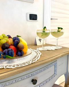卡斯泰拉罗La Vista del Poggio的桌上一碗水果和两杯饮料