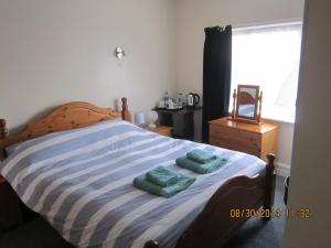 浦耳玛丽宾馆的一间卧室配有一张带两张绿毛巾的床