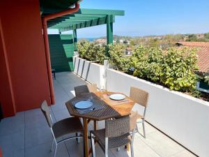 圣让-德吕兹Superbe appartement, grande terrasse vue mer et montagne的美景阳台配有桌椅