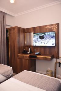 麦地那Dar Al Naem Hotel的配有一张床和一台平面电视的酒店客房