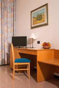 阿尔贝罗贝洛阿斯托利亚酒店的客房设有一张桌子、一台电脑和一把椅子