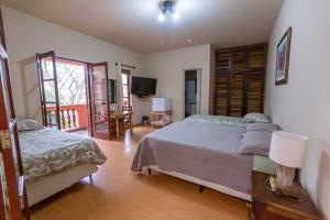 圣本图-杜萨普卡伊Pousada do Sitio的一间卧室配有两张床和电视。