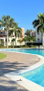 圣地亚哥洛斯卡巴Sweet Home的度假村内棕榈树游泳池