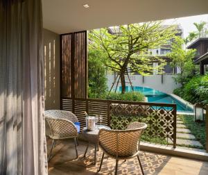 清迈Maladee Rendezvous Hotel Chiang Mai的一个带桌椅的庭院和一个游泳池