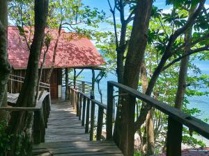 俊穆岛林山海简易别墅的通往海滩上的度假胜地的木制走道