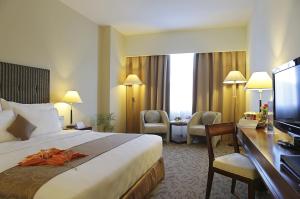 查亚普拉ASTON Jayapura Hotel and Convention Center的配有一张床和一张书桌的酒店客房