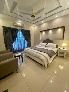 拉瓦尔品第Luxury Guest House in Bahria Town的一间卧室配有一张大床和一张沙发