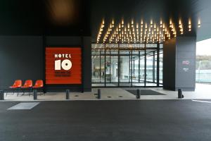 玉野市SETOUCHI KEIRIN HOTEL 10 by Onko Chishin的一座带橙色椅子的建筑,上面标有编号