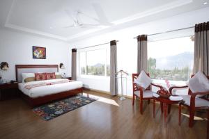 列城The Zen Ladakh的卧室配有一张床和一张桌子及椅子
