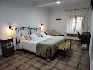 马尔帕尔蒂达德普拉森西亚Casa Rural el Rincón de Monfragüe的一间卧室配有一张大床和一架钢琴