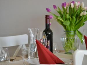 LeisnigFerienwohnung auf Gut Börtewitz的一张桌子,上面放着一瓶葡萄酒和一瓶鲜花