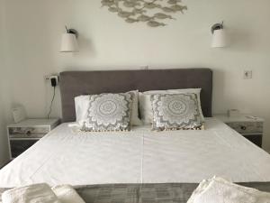 卡西奥皮Corfu island apartment in KASSIOPI by seaside的卧室配有一张带两个枕头的大白色床