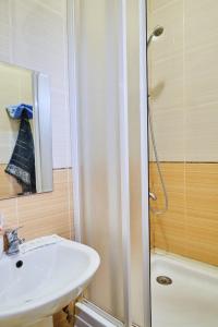 苏梅Троицкая люккс апартамены посуточно почасово的浴室配有盥洗盆和带镜子的淋浴