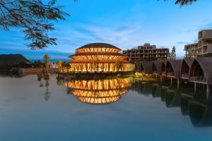 宁平Wyndham Grand Vedana Ninh Binh Resort的水体上座的建筑物