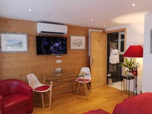 勒布罗伊斯Chalet la Cachette Cyclists & Skiers的客厅配有红色的沙发、桌子和椅子