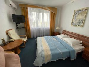 切尔卡瑟Dnipro Hotel的酒店客房配有一张床、一张书桌和一台电视。