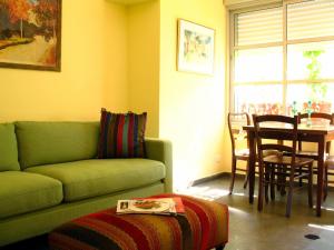 特拉维夫TLV Living Apartment的客厅配有绿色沙发和桌子