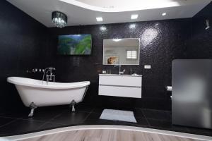 海法Luxury Room Bahai's Garden的黑色浴室设有浴缸和水槽