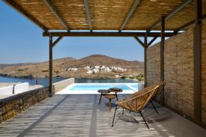 基斯诺斯Amal Kythnos Suites的一个带桌椅的庭院和一个游泳池