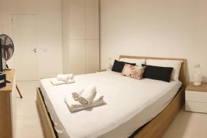 兰佩杜萨RgB_Apartments的卧室配有带毛巾的大型白色床