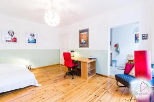 柏林Sunny Studio at Wismarplatz的一间卧室配有书桌和一张带红色椅子的床