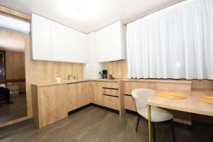 加拉茨Fly Central Park 2的厨房配有木制橱柜和桌椅