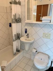 汉诺威翰诺威普罗梅西酒店的白色的浴室设有卫生间和水槽。